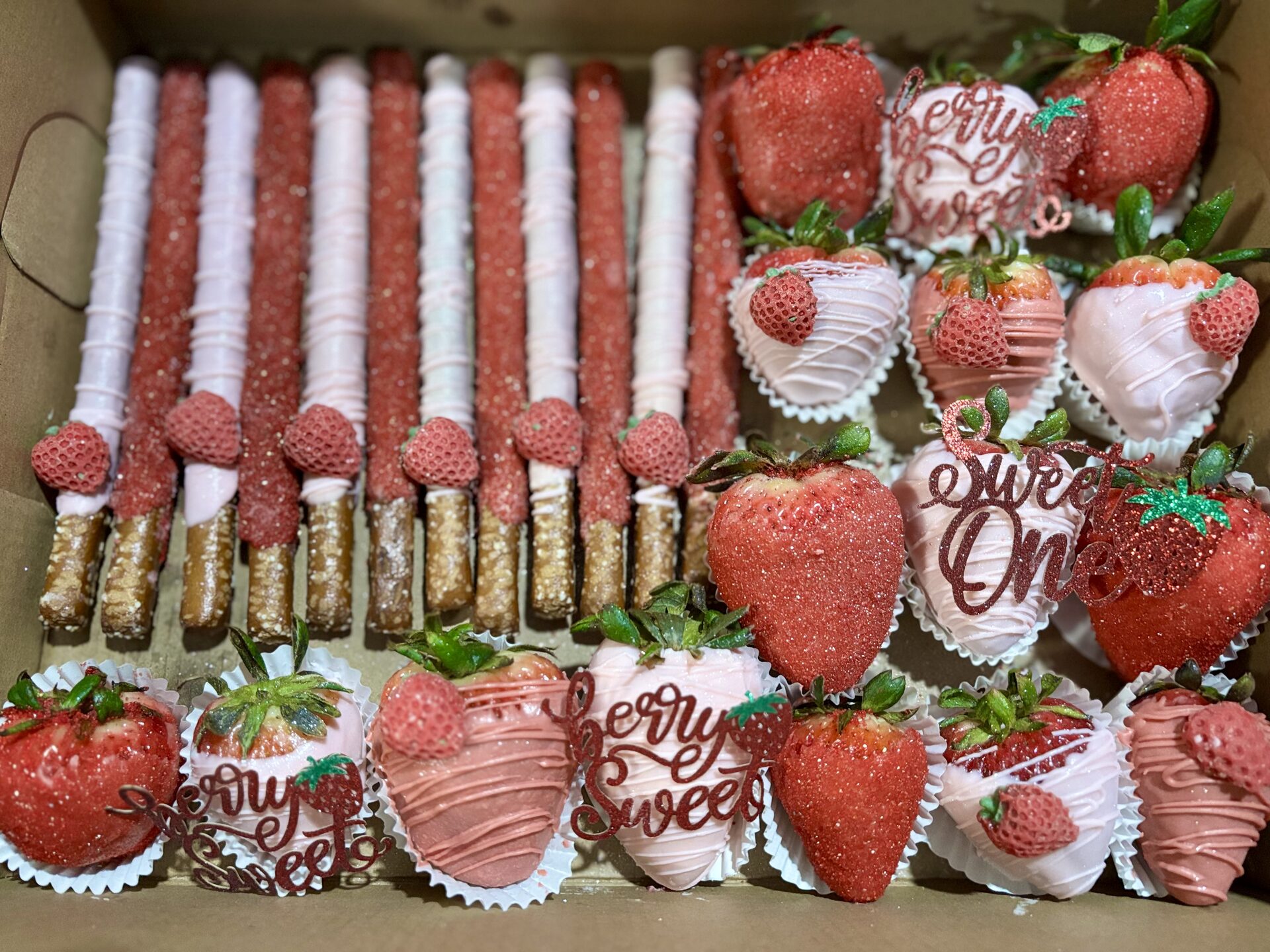 Pink chocolate-covered strawberries and pretzel rods